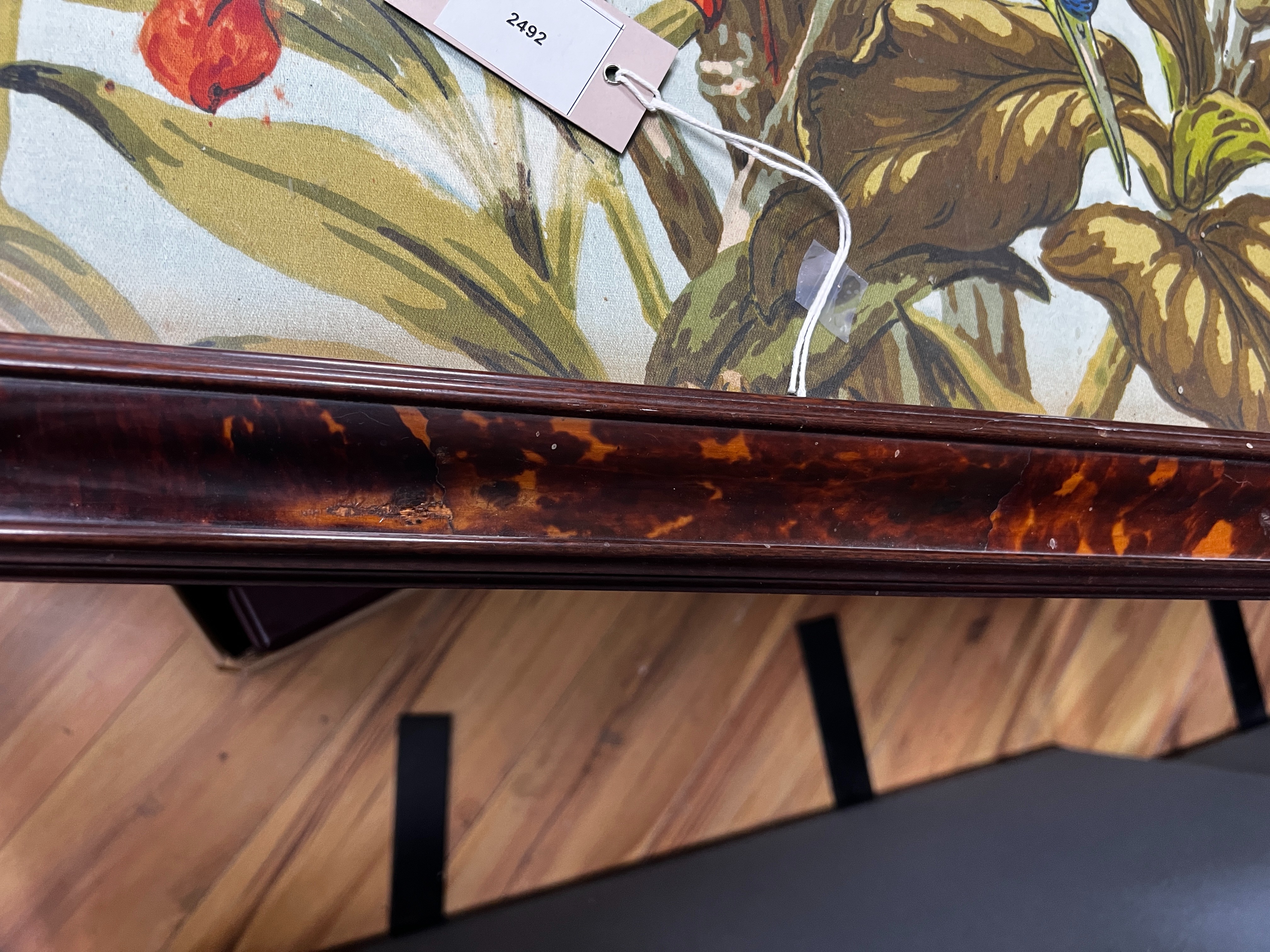 A large rare tortoiseshell picture frame and exotic panel of printed fabric, 70 cms wide x 52 cms high including frame